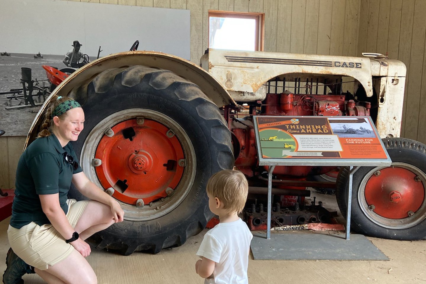 woman with child in front of tracktor