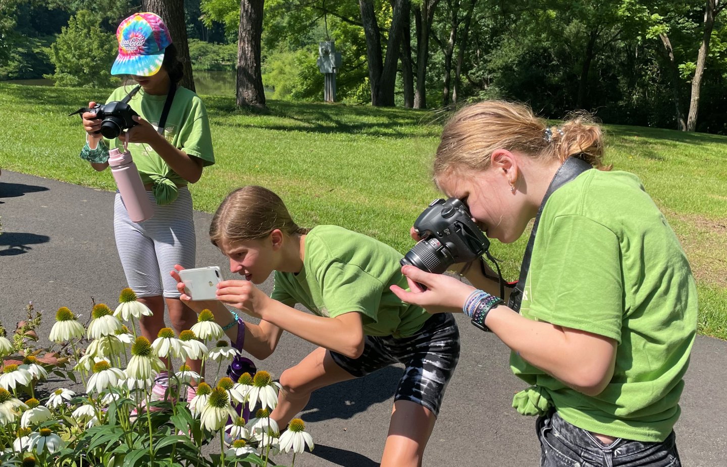 Two girls taking photo of flowers