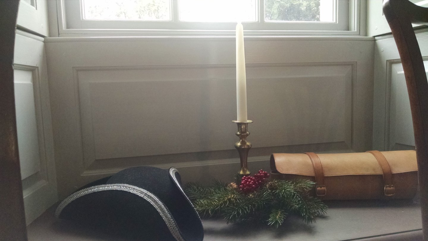 Tricorn hat, candle, and greenery in window seat