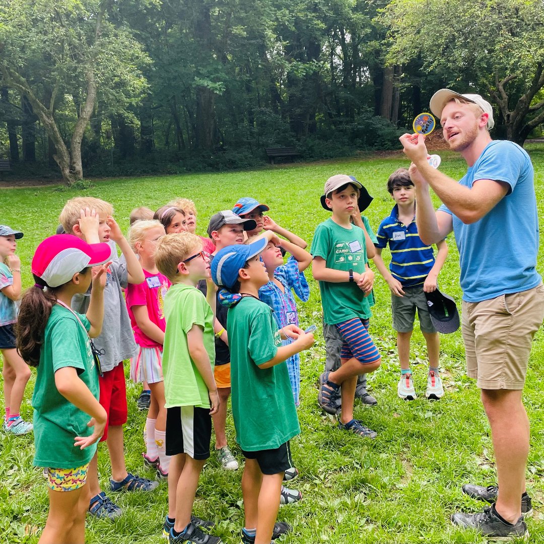 kids with counselor in a grassy field