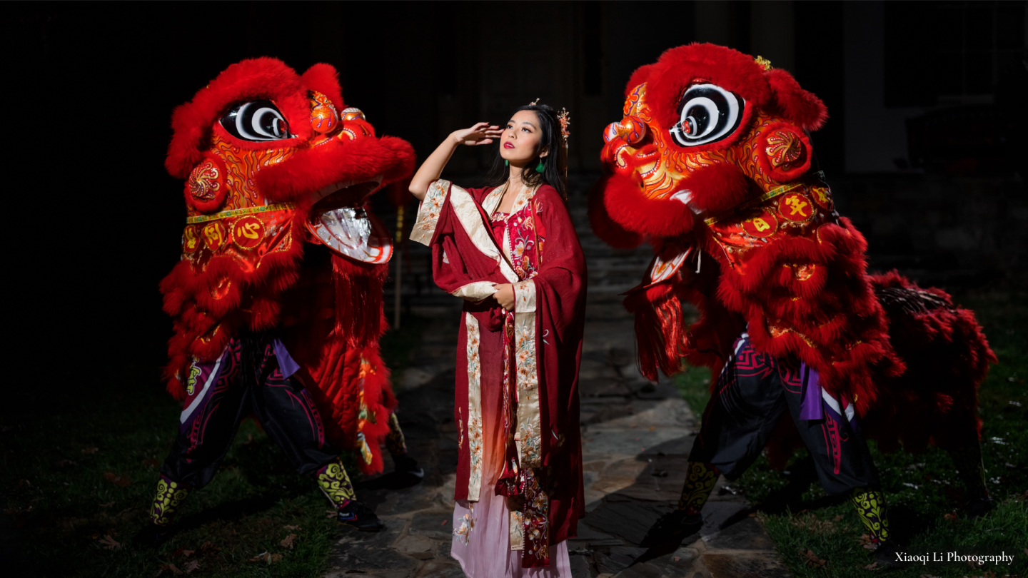 Women wearing traditional Chinese costume with two Chinese dancing dragons on either side of her