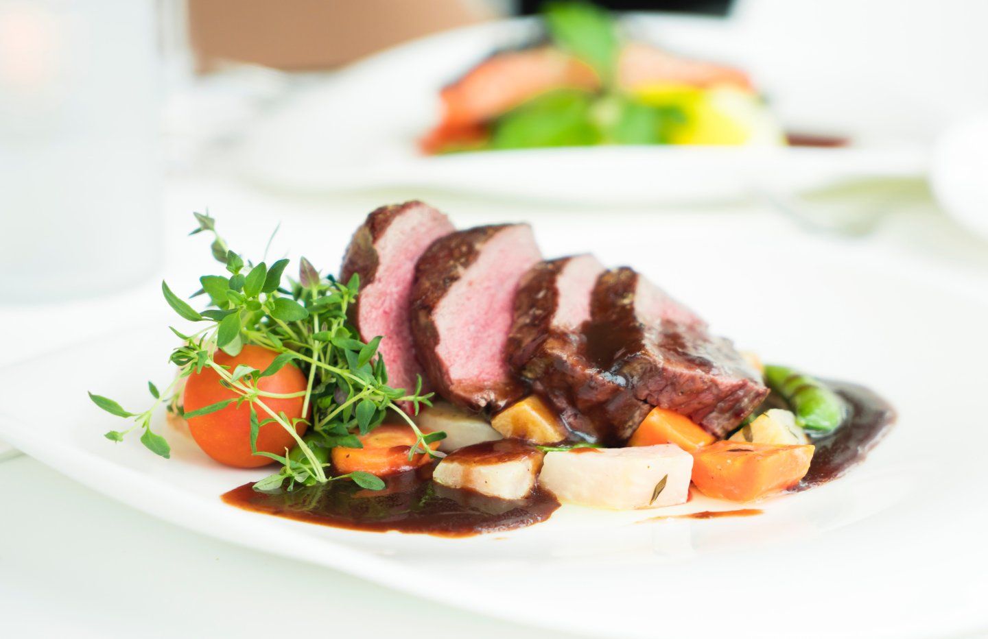 Steak with parsley garnish au ju sauce carrots and potatoes