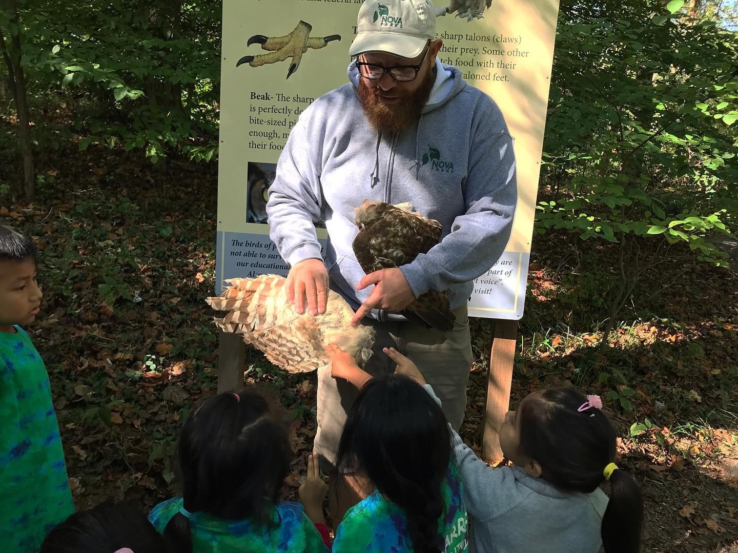 NOVA Parks Roving Naturalist holding birds wings with kids in foreground