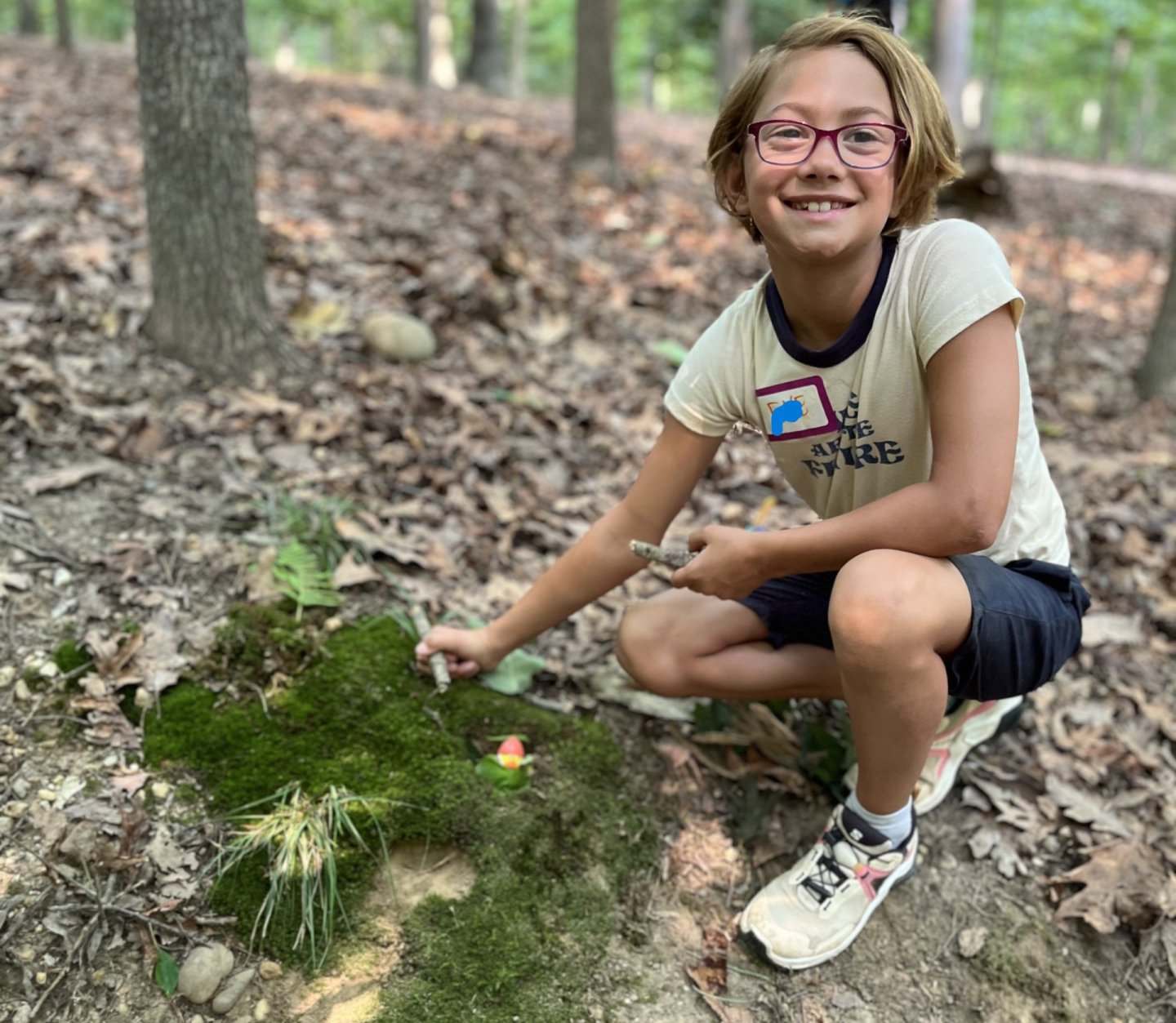 Girl in woods exploring moss