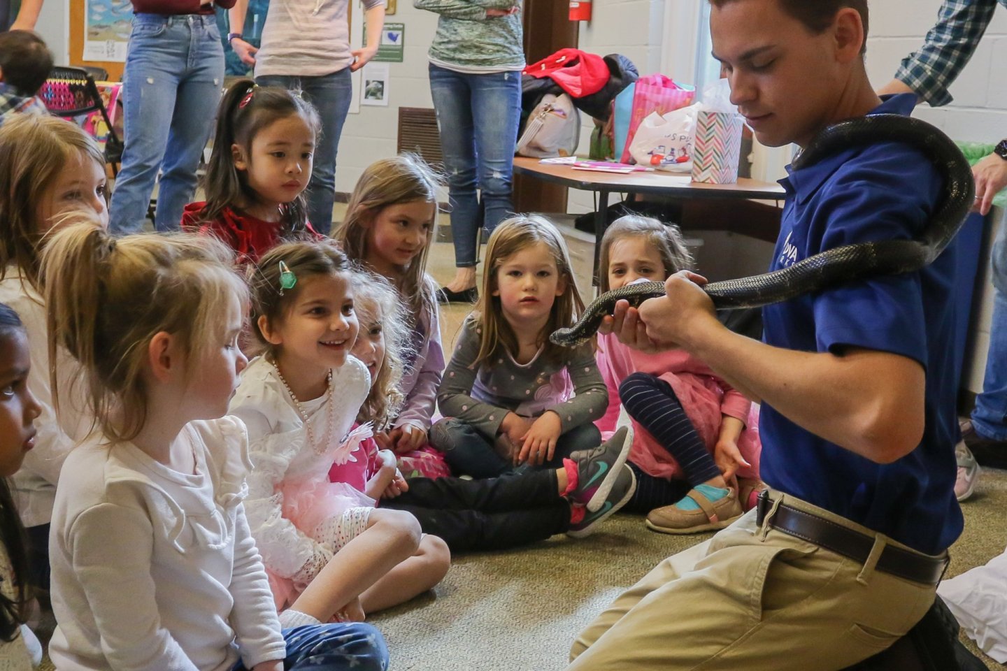 NOVA Parks employee holding a snack with girls at birthday party watching demonstrartion