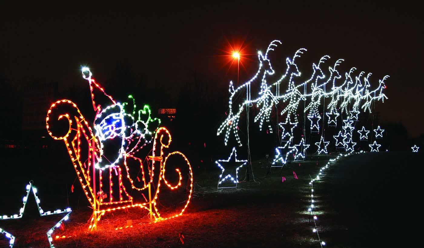 Holiday lights featuring Santa Claus riding in a sled being pulled by his reindeer