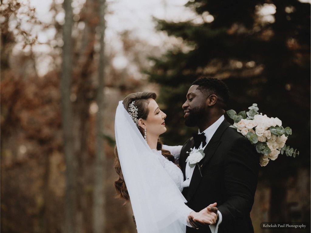 Rust Manor House bride and groom hugging with sunset behind them