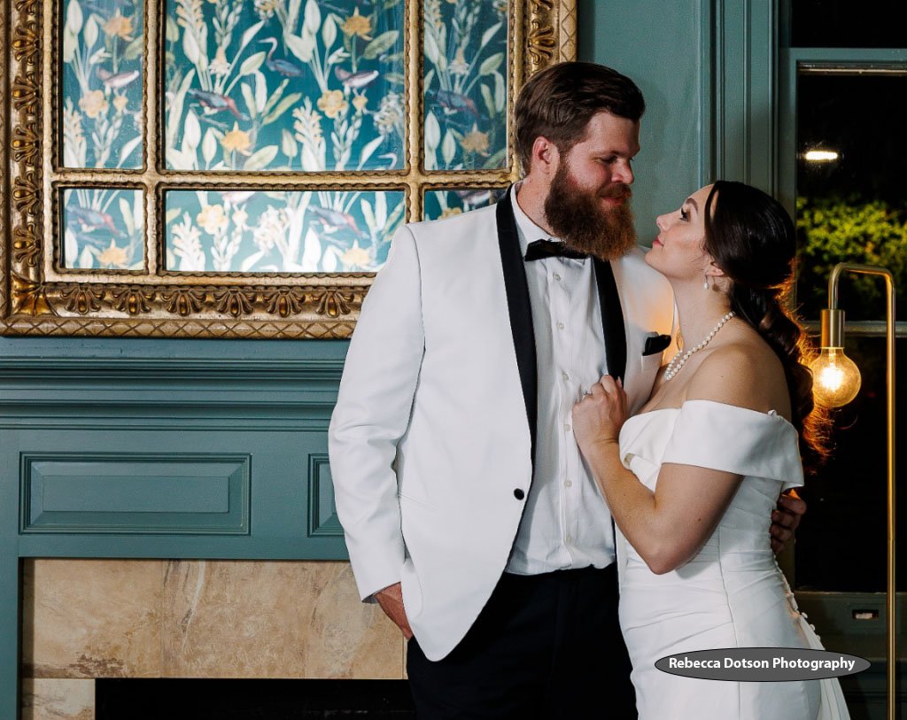 Rust Manor House bride and groom in front of fireplace