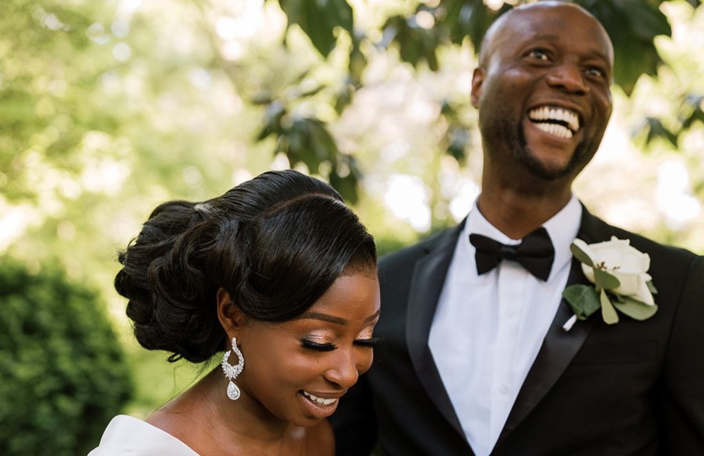 Bride and groom smiling with trees and greenery in the background