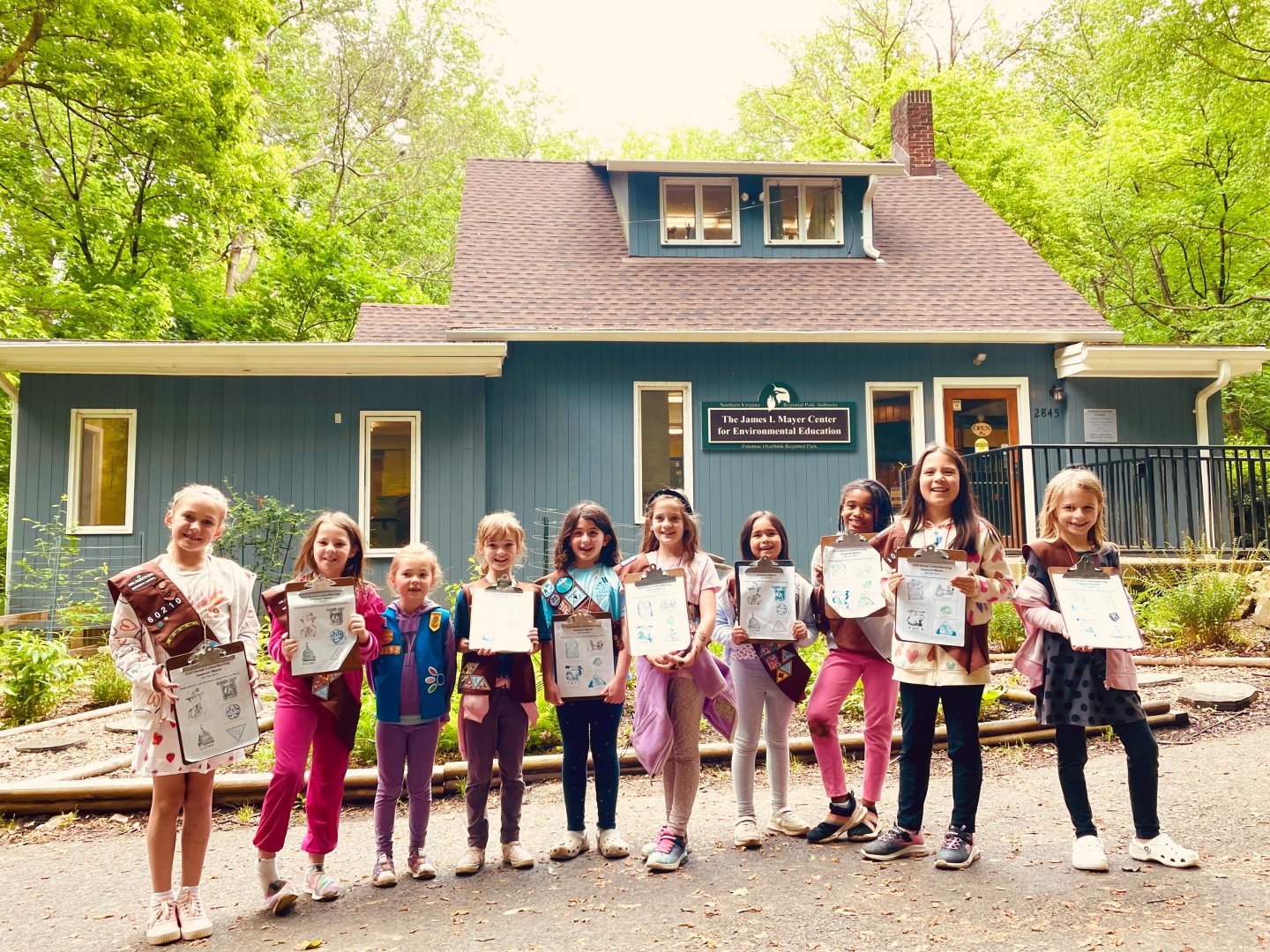 10 girl scouts standing in front of the Potomac Overlook Nature Center