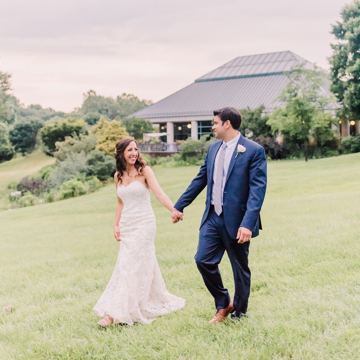 Newlyweds holding hands in front of The Atrium