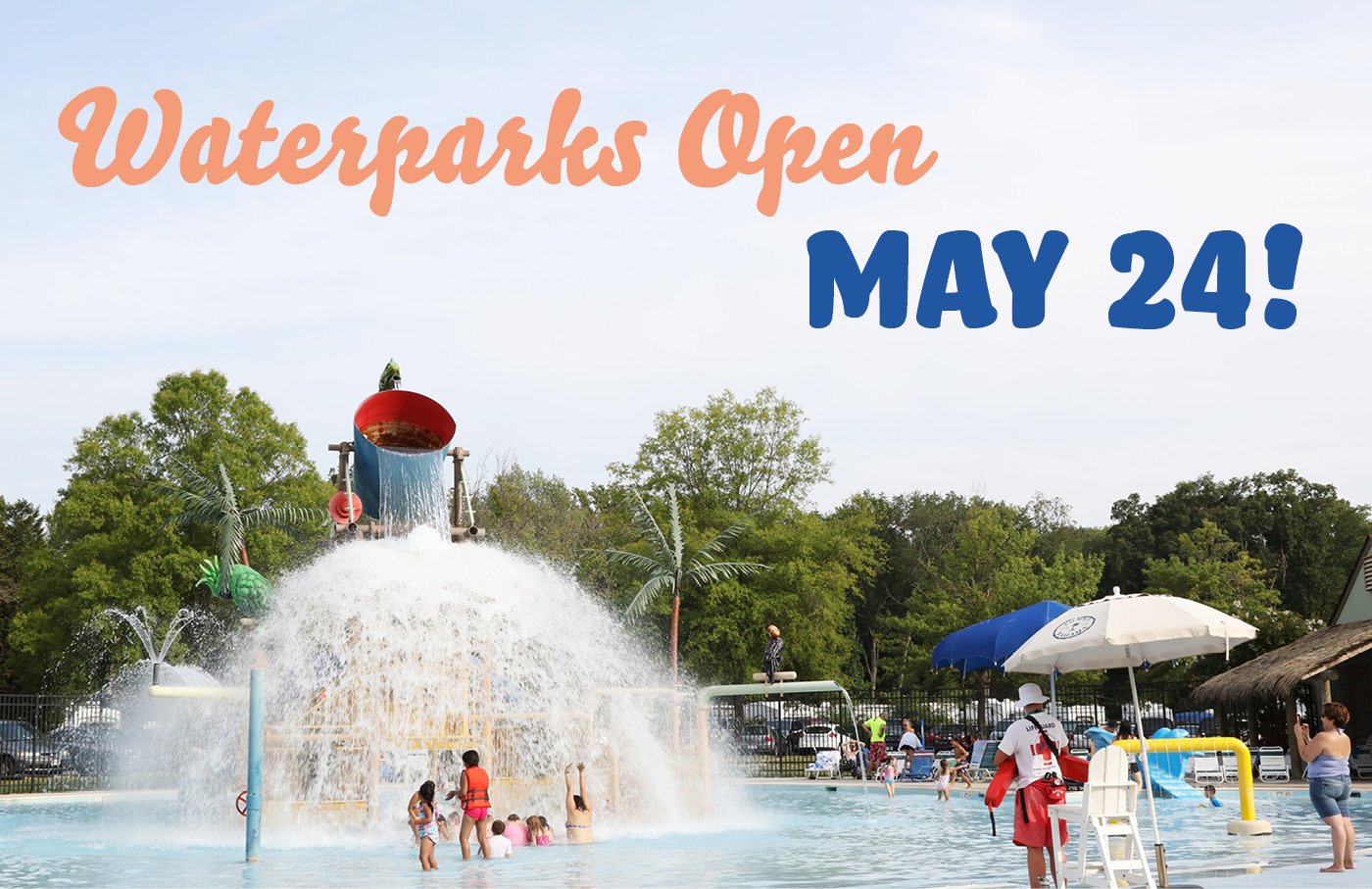 Crowded waterpark with a large splash pad under blue skies.