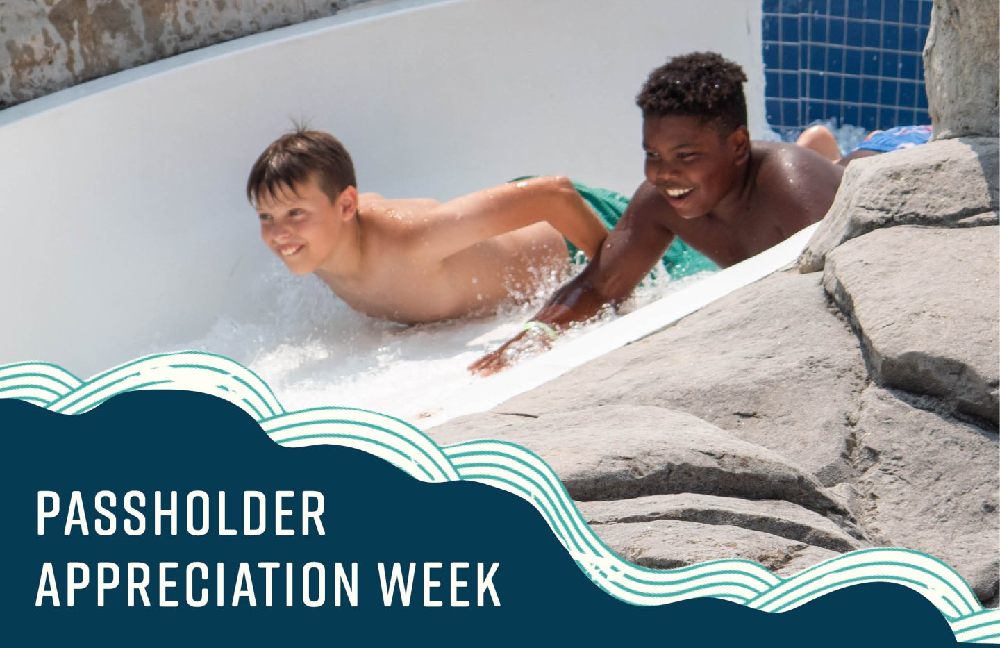 Two boys enjoying a water slide, smiling and splashing.