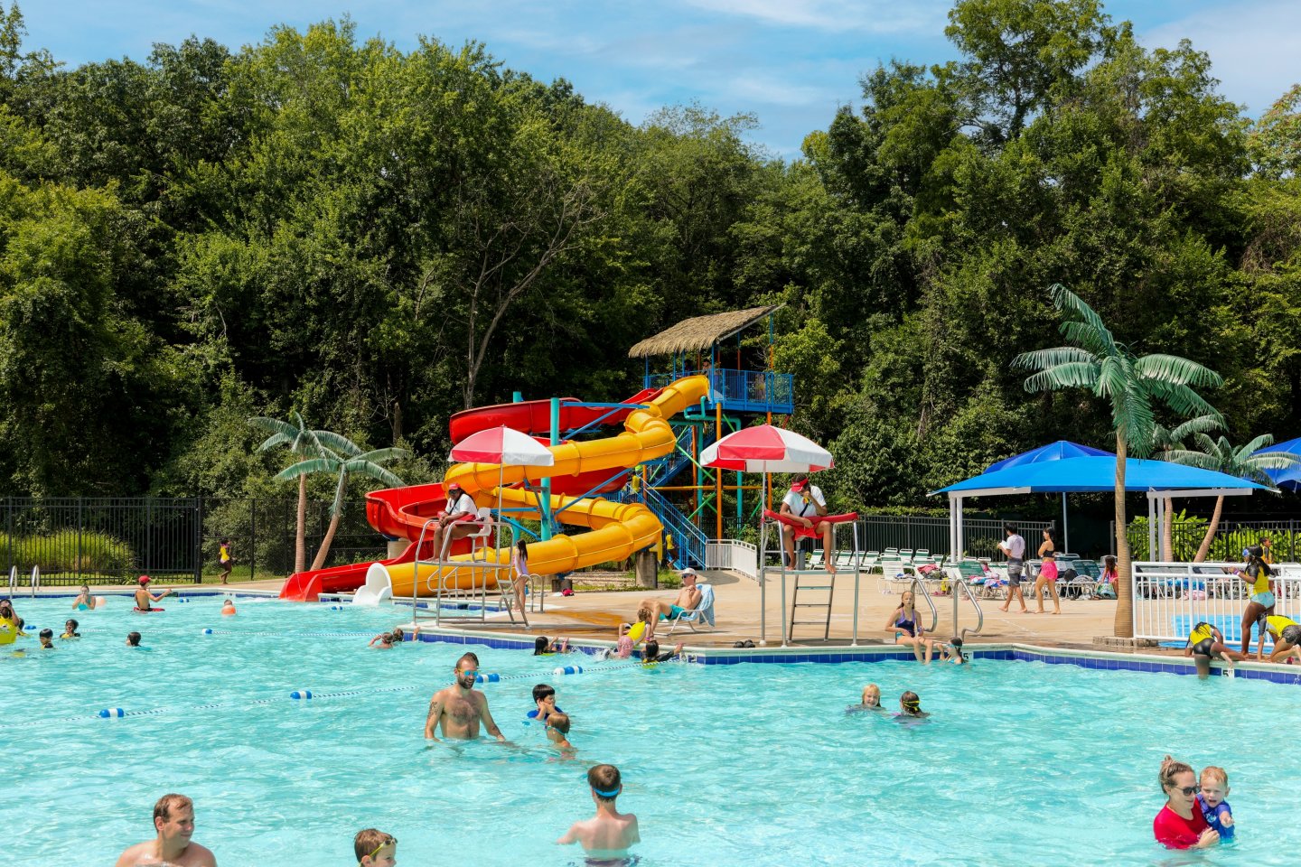 Volcano Island Waterpark scene with waterslides and people swimming.