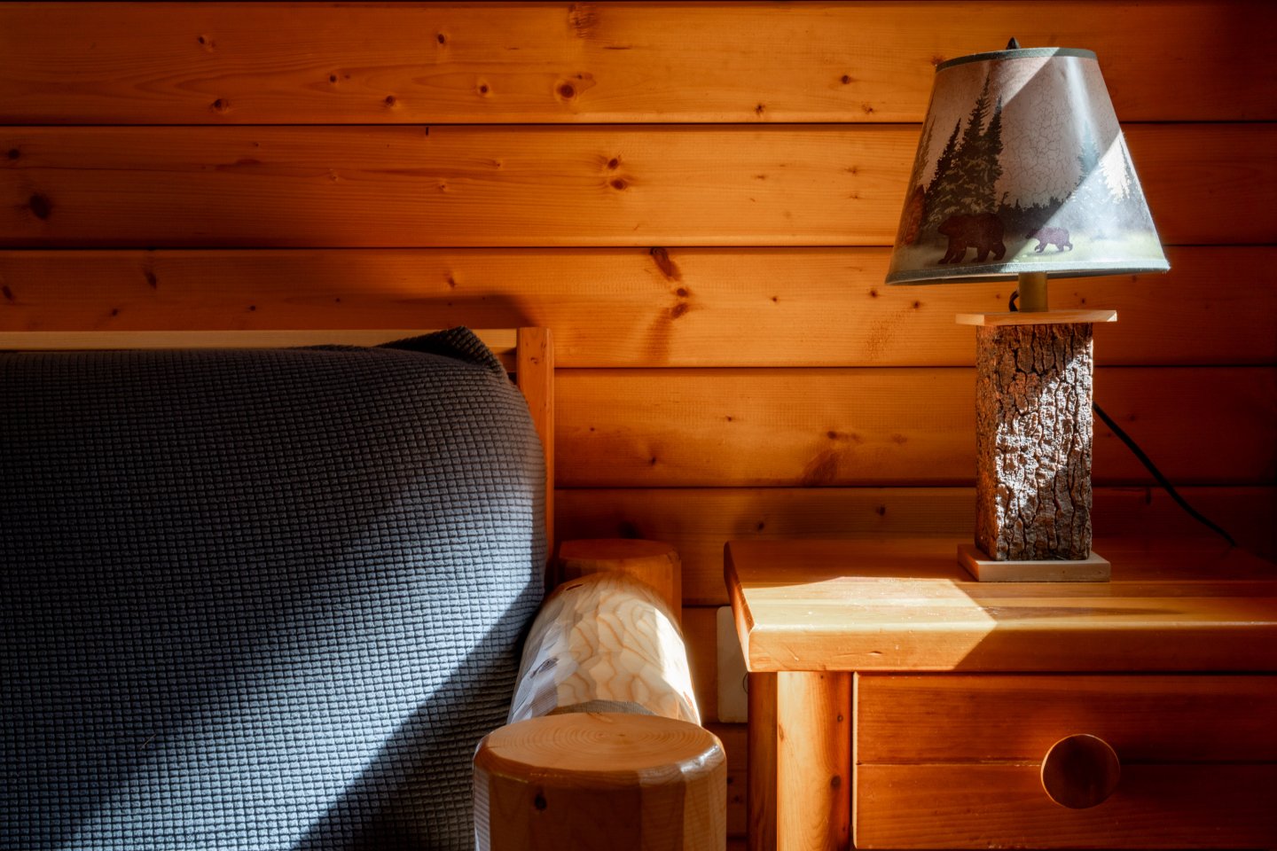 Cozy wooden living room with a lamp on a nightstand.