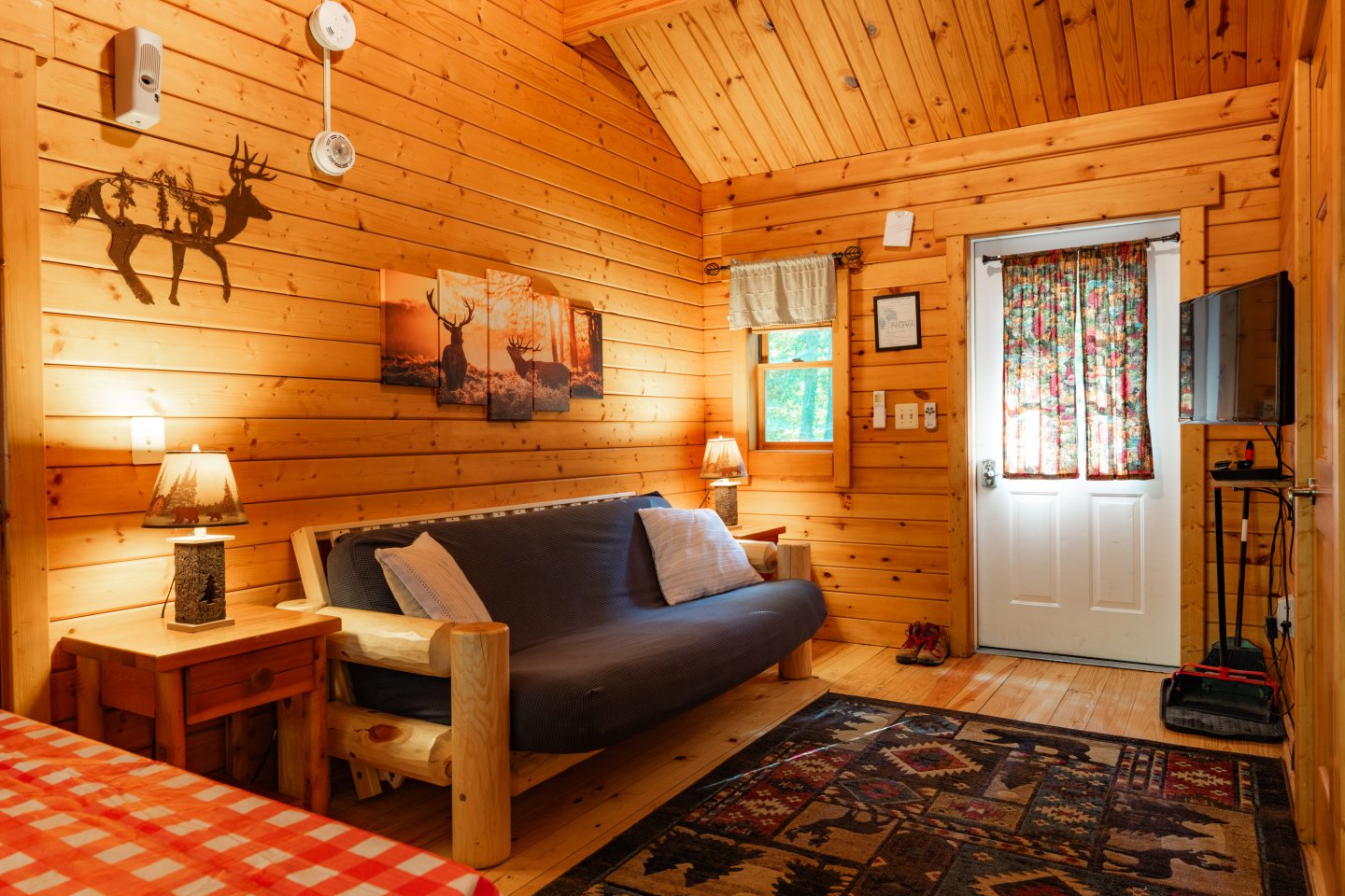 Cozy wooden cabin interior with a blue sofa and rustic decor.