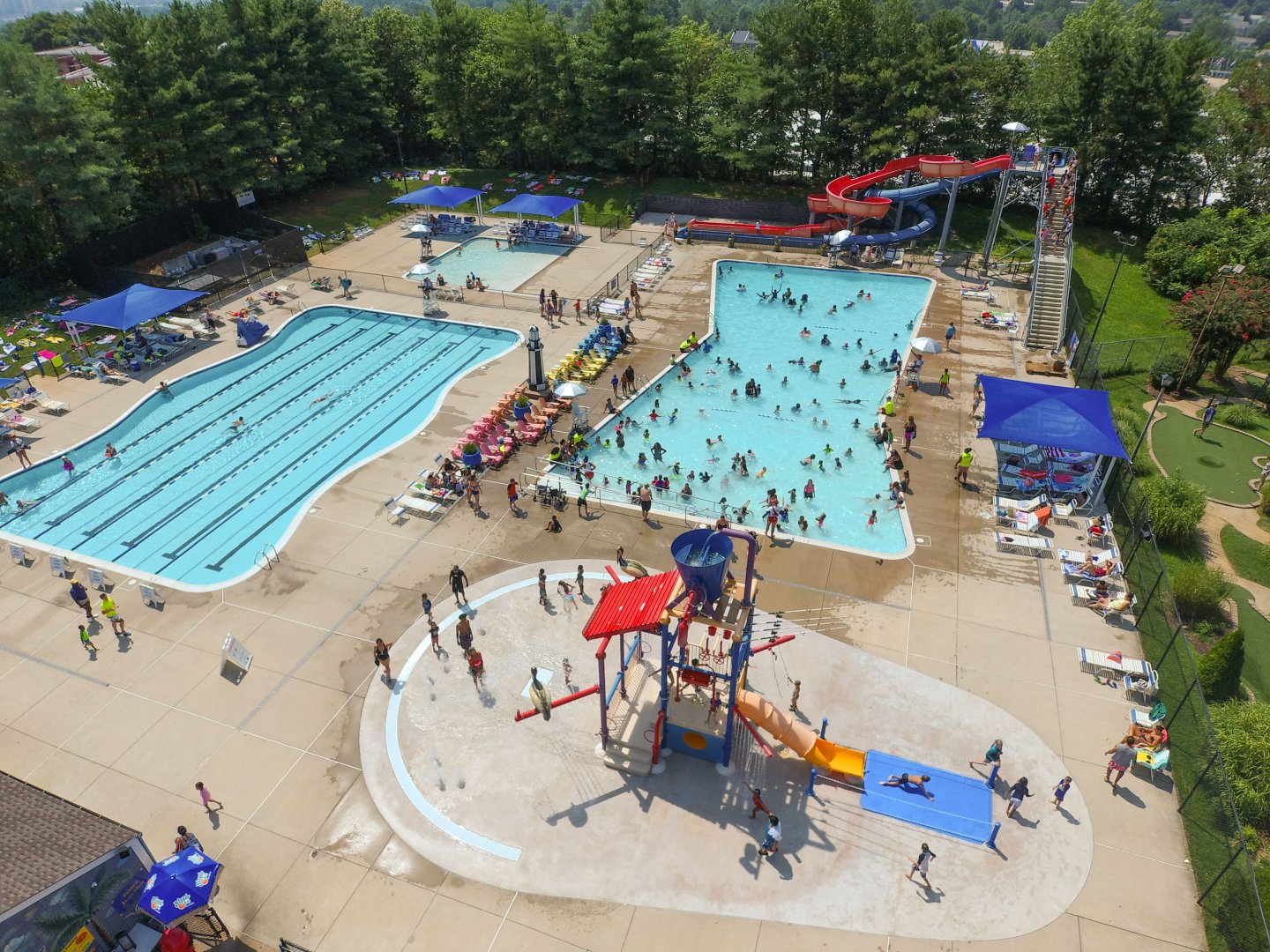 Aerial view of a busy outdoor water park with pools and slides.
