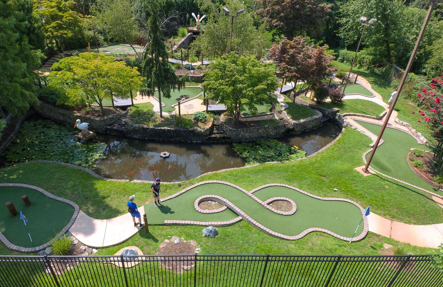 Mini golf course with winding paths and lush greenery.