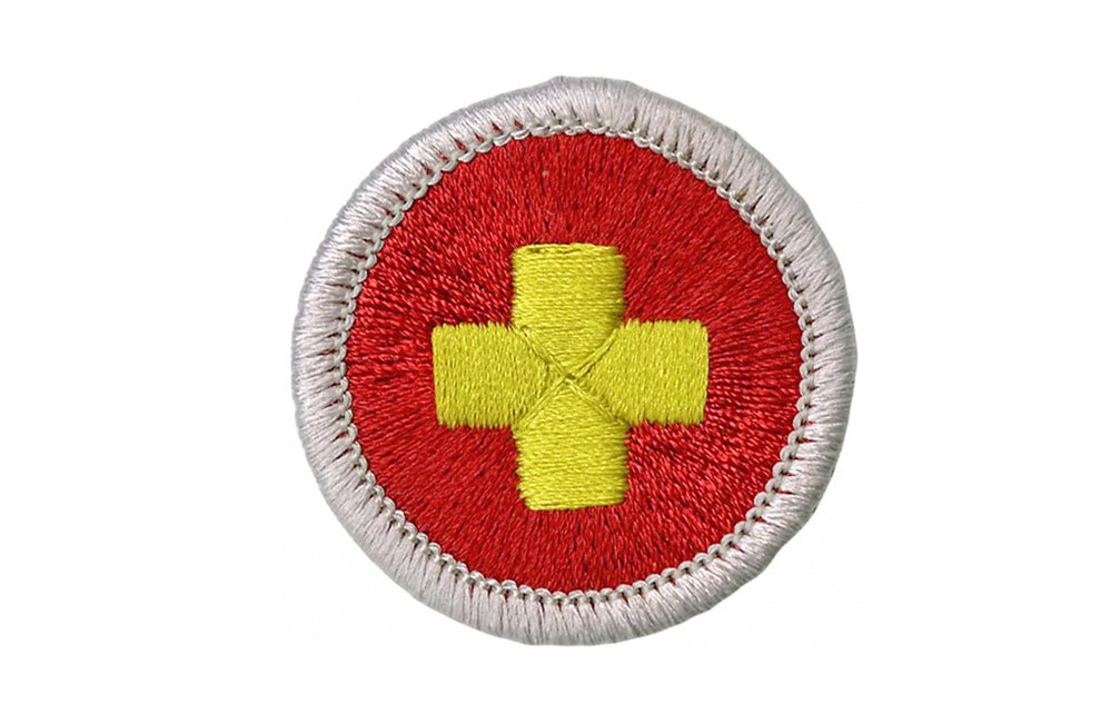 Round badge with yellow cross on a red background, white border.