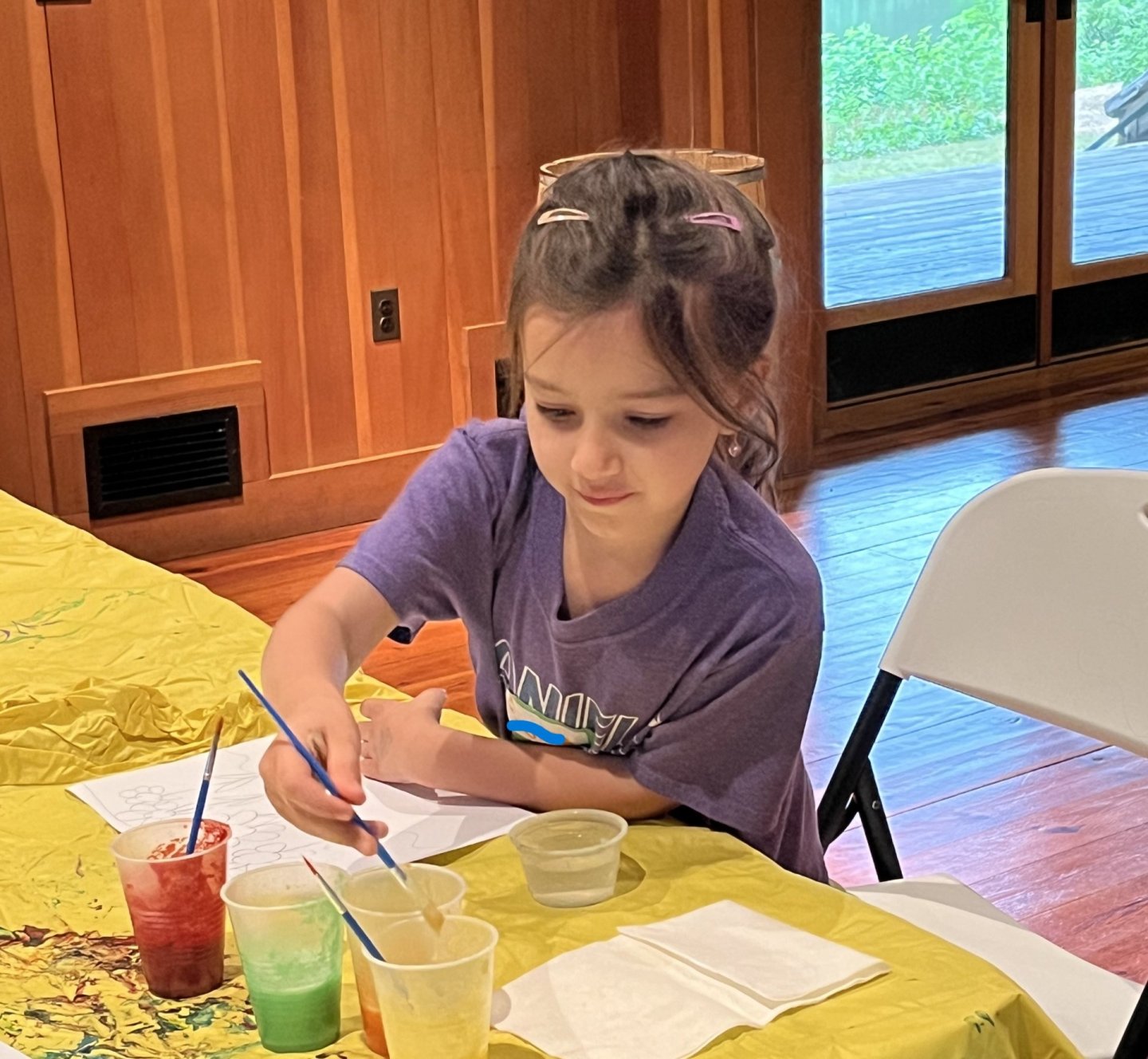 Child painting at a table indoors.
