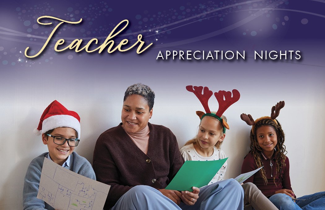 Smiling teacher with children in festive hats, holding papers.