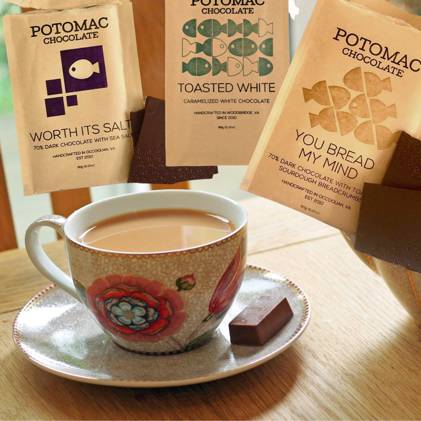 Tea cup on saucer with chocolate and wrappers in the background.