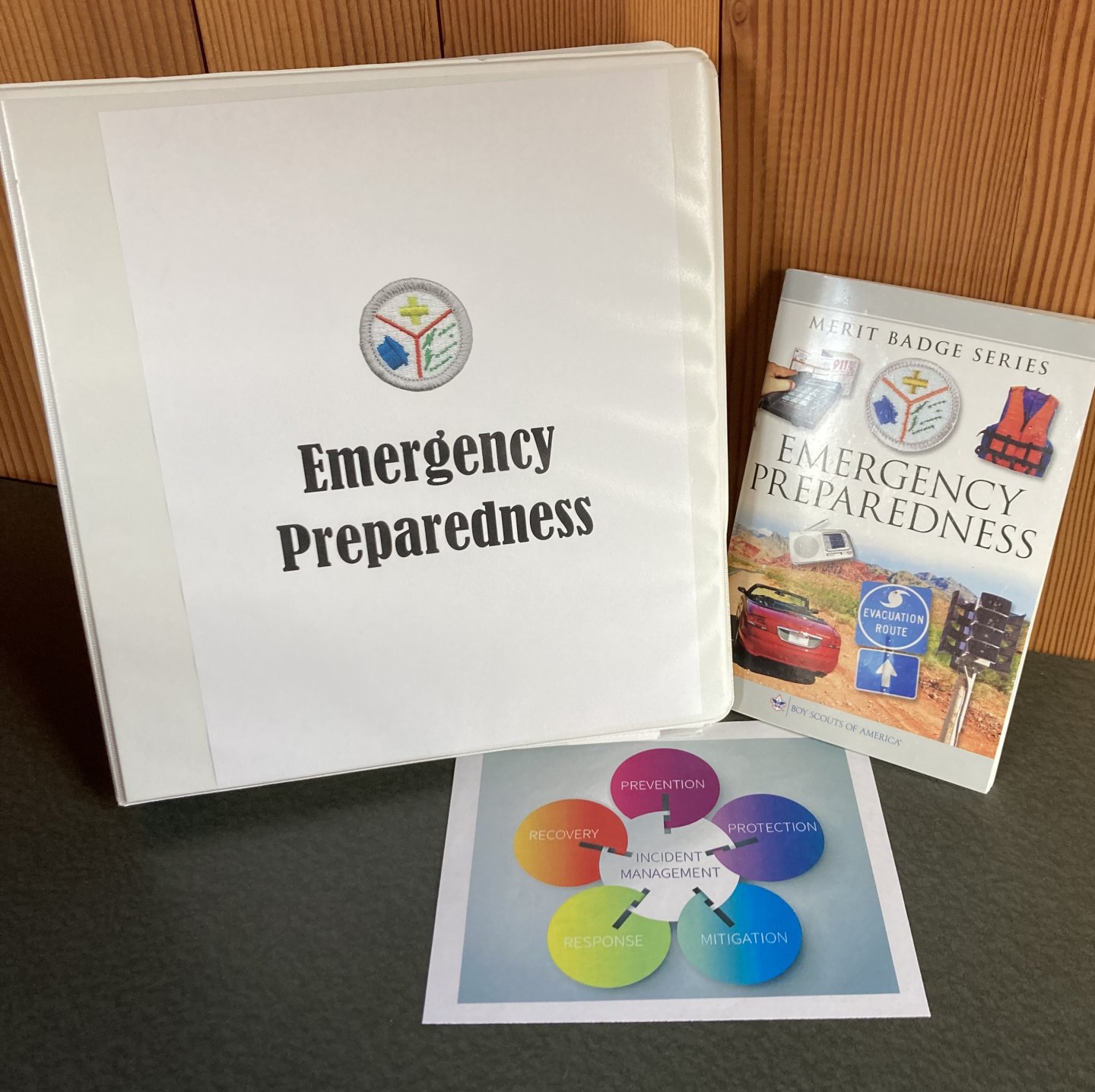 Emergency preparedness binder, booklet, and colorful planning chart on a table.