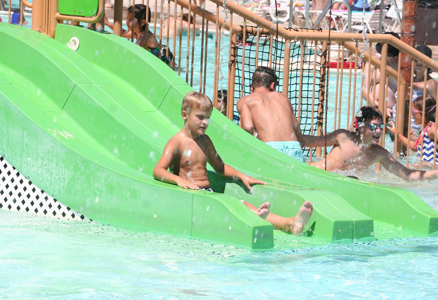 boy sliding into pool